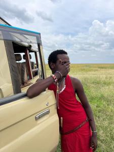 a woman standing in front of a vehicle at leyianmaasaisafaris in Narok
