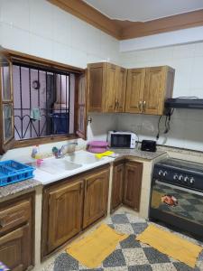 a kitchen with wooden cabinets and a sink at Apartment Gilbert in Alger