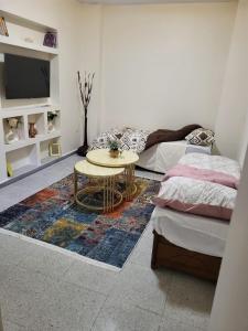 a room with two beds and a table with a rug at Apartment Gilbert in Alger