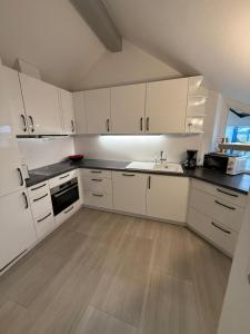 a white kitchen with white cabinets and a sink at Viktoria`s Penthouse in Bad Breisig