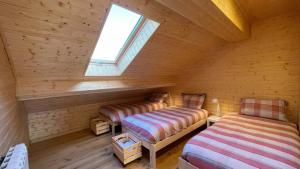 a room with two beds in a log cabin at Chalet Serra 1506 Geopark S Estrela in Penhas da Saúde