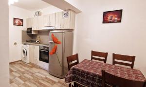 a small kitchen with a table and a refrigerator at Alex City Apartment Gabrovo in Gabrovo