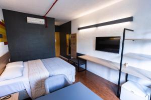 a small hotel room with a bed and a desk at Hotel 10 Curitiba in Curitiba +50 photos