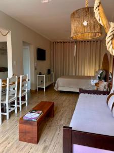 a living room with a bed and a table at Apto estúdio na praça central in Serra Negra
