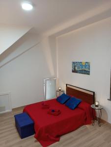 a bedroom with a red bed with blue pillows at Appartamento rosso blu in Vernazza