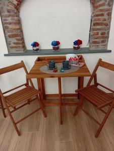 a wooden table with two chairs and a table with cupcakes at Appartamento rosso blu in Vernazza