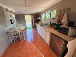 a kitchen with a counter and a table with a microwave at Uys Cottage on 79 in Heidelberg