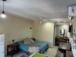 a small room with a bed and a kitchen at Departamento para 2 pers con vista a las sierras OC in Villa Giardino