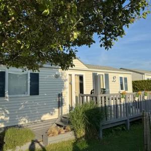 a white house with a fence in front of it at Claire's Cottage in Knokke-Heist