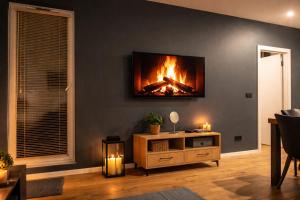 a living room with a fireplace on the wall at APART FLOW Walendów Park in Nadarzyn