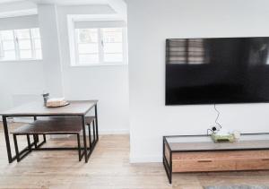 a living room with a table and a tv on a wall at Cosy & Luxury 2BR Flat in Calverton in Calverton