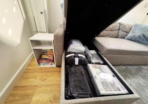 a room with a couch with an open suitcase at Cosy & Luxury 2BR Flat in Calverton in Calverton