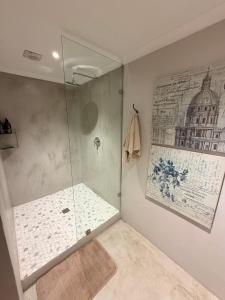 a bathroom with a shower and a painting on the wall at Uys Cottage on 79 in Heidelberg +12 photos