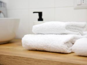 a stack of white towels sitting on a counter at Appartamenti Ventuno in Riva del Garda +27 photos