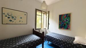 a room with two beds and a window at Villa Luce by Italy Home eXperience in Santa Marinella
