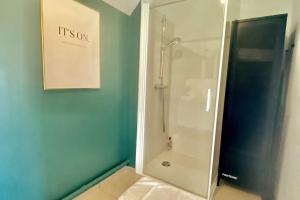 a shower stall in a bathroom with a blue wall at Appartement Vue Château - parking privé - 80m2 - Vaugueux Caen in Caen +14 photos