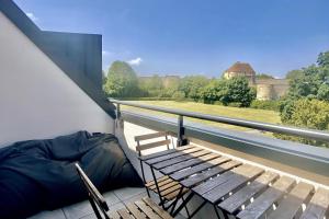 a balcony with a bench and a view of a castle at Appartement Vue Château - parking privé - 80m2 - Vaugueux Caen in Caen