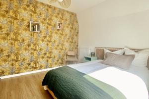 a bedroom with a bed with a yellow and green wallpaper at Appartement Vue Château - parking privé - 80m2 - Vaugueux Caen in Caen