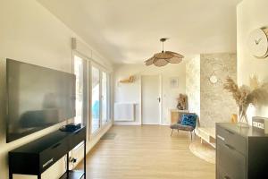 a living room with a large flat screen tv at Appartement Vue Château - parking privé - 80m2 - Vaugueux Caen in Caen