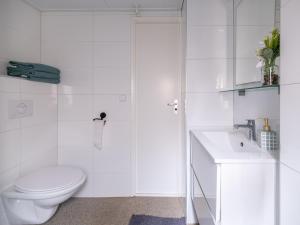 a white bathroom with a toilet and a sink at Ermmoon Cottage in Erm +11 photos