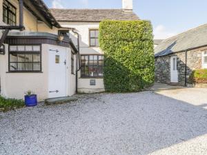 a house with a hedge next to a garage at The Farmhouse in Keswick