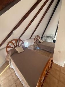 a attic room with two beds and a table at El Molino de Valverde in Elche