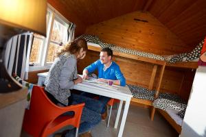 een man en een vrouw aan een tafel in een kamer bij Dromen bij de boer in Oene