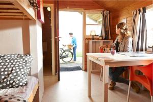 a woman sitting at a table in a tiny house at Dromen bij de boer in Oene