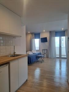 a kitchen and a living room with a bed in a room at Aparthotel ALMARIS in Es Pujols +20 photos
