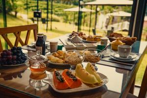 a table topped with plates of food and fruit at Vinícola & Pousada Terragnolo in Bento Gonçalves