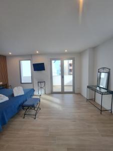 a large room with a bed and a tv at Aparthotel ALMARIS in Es Pujols