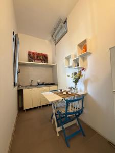 a small kitchen with a table and a blue chair at casa surano in Diso
