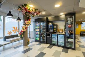a grocery store with a flower wreath on a column in a store at Premiere Classe Roissy Aéroport Charles De Gaulle in Roissy-en-France
