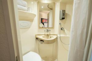 a bathroom with a sink and a toilet and a shower at Premiere Classe Roissy Aéroport Charles De Gaulle in Roissy-en-France +56 photos