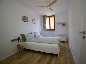 a bedroom with a bed and a ceiling fan at Appartamenti Ventuno in Riva del Garda