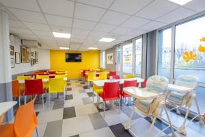 a dining room with colorful chairs and tables at Premiere Classe Roissy Aéroport Charles De Gaulle in Roissy-en-France