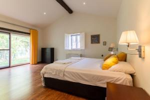 a bedroom with a large bed with yellow pillows at Casal do Aviador in São Vicente do Paul +55 photos