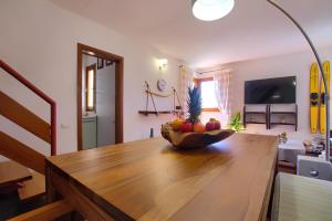 a kitchen with a wooden table with a bowl of fruit at 20 passi dalla spiaggia - Panoramic Duplex in Porto Rotondo