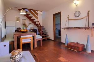 a kitchen and dining room with a table and a clock at 20 passi dalla spiaggia - Panoramic Duplex in Porto Rotondo