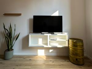 a living room with a television on a white cabinet at Appartamenti Ventuno in Riva del Garda
