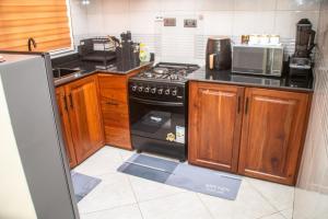 a kitchen with a black stove and a microwave at Aiden House Arusha in Arusha