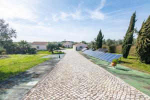 a cobblestone road with solar panels on a house at Casal do Aviador in São Vicente do Paul