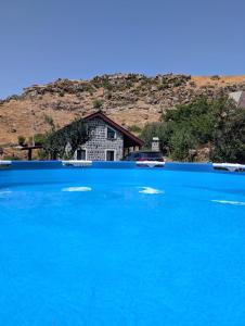 a blue lake with a house in the background at River Home Villa in Kʼaghsi
