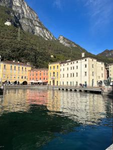 a body of water with buildings and a mountain at Appartamenti Ventuno in Riva del Garda