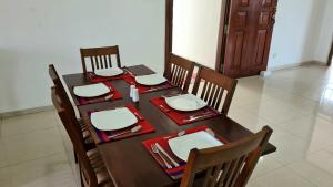 a dining room table with chairs and a table with plates at Oceanway Residences in Wattala
