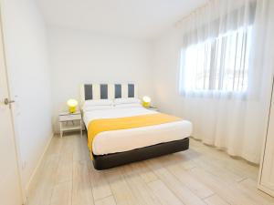a bedroom with a bed and a window at Castell Beach Aparthotel in Castelldefels +11 photos