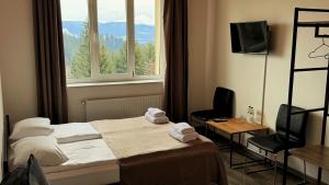 a hotel room with a bed and a window at Готель Яблуниця in Yablunytsya
