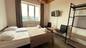 a hotel room with a bed and two chairs at Готель Яблуниця in Yablunytsya