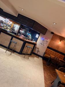 a bar in a restaurant with chairs and a counter at The Turf Hotel in Richmond