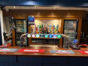 a bar with a counter with alcohol bottles at The Turf Hotel in Richmond +17 photos